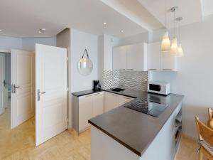 une cuisine avec des placards blancs et un comptoir noir dans l'établissement Appartement Menton, 3 pièces, 5 personnes - FR-1-196-184, à Menton