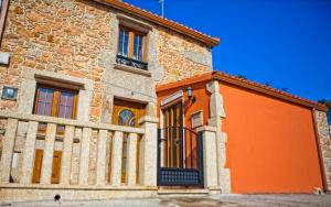 un edificio naranja con una valla delante en Casa Marcelino, en Muxía