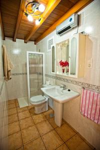 uma casa de banho com um lavatório, um WC e um espelho. em Casa Marcelino em Muxía