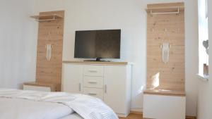 a bedroom with a bed and a tv on a wall at Rosenwinkel Appartement im OG in Halberstadt