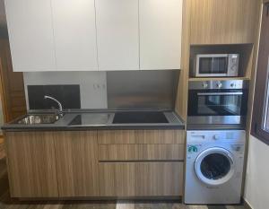 a kitchen with a sink and a stove and a microwave at Dúplex Rural Casa Bergua in Arguis +4 photos