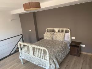 a bedroom with a white bed with a wooden floor at Dúplex Rural Casa Bergua in Arguis