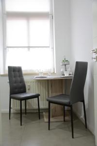 duas cadeiras sentadas ao lado de uma mesa numa cozinha em Charmantes tierfreundliches Gästeappartement em Harsleben