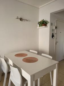 una mesa de comedor blanca con sillas blancas en Luminoso departamento en el corazón de la ciudad en Mar del Plata