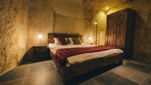 a bedroom with a bed with a wooden head board at Cappadocia Old Houses in Nevsehir