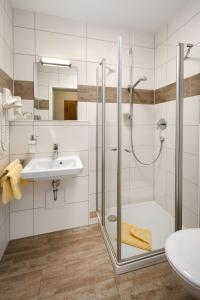 uma casa de banho com um chuveiro e um lavatório. em Hotel Zur Post em Bad Abbach