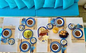 a table topped with blue and white plates of food at Thalia Myconian Suites in Kalafatis