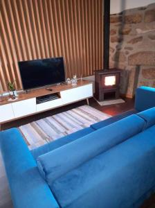 a blue couch in a living room with a fireplace at Casa do Eirô in Pinheiro