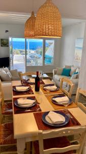 una mesa de comedor con platos y copas de vino. en Thalia Myconian Suites en Kalafatis