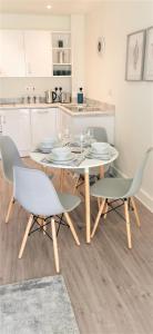 a white table and chairs in a kitchen at Sea Breeze, gorgeous 2 bed apartment in Exmouth in Exmouth