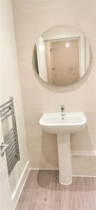a bathroom with a sink and a mirror at Sea Breeze, gorgeous 2 bed apartment in Exmouth in Exmouth