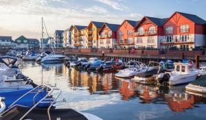 a group of boats docked in a marina with houses at Sea Breeze, gorgeous 2 bed apartment in Exmouth in Exmouth