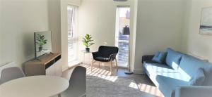 a living room with a blue couch and a table at Sea Breeze, gorgeous 2 bed apartment in Exmouth in Exmouth