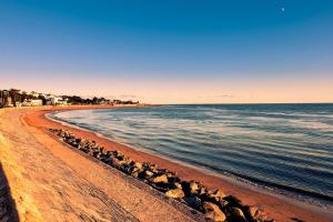 a beach with rocks and the ocean and buildings at Sea Breeze, gorgeous 2 bed apartment in Exmouth in Exmouth +9 photos