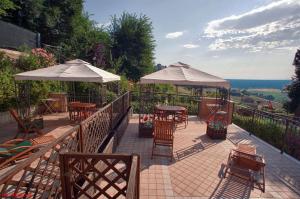 a patio with tables and chairs and umbrellas at La casa di Carla in Fermo +64 photos