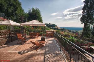 a patio with chairs and tables and umbrellas at La casa di Carla in Fermo