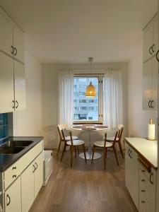 a kitchen with a table and chairs and a window at Keskusta kaksio Tuomiokirkon ja Yliopiston lähellä in Turku