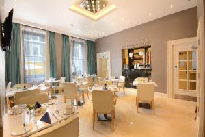 una sala da pranzo con tavoli e sedie e un ristorante di Park Grand London Lancaster Gate a Londra