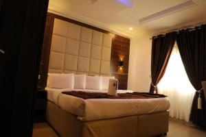 a bedroom with a bed with a laptop on it at Presken Hotel (Reliance) in Ikeja