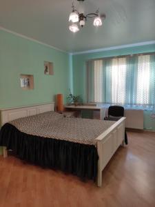 a bedroom with a large bed and a desk at Oasis Apartments in Pärnu