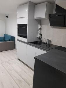 a kitchen with white cabinets and a black counter top at Apartament na zakręcie in Karpacz