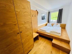 een slaapkamer met een bed en een grote houten kast bij Tiroler Zeitgeist Apartment Fügen in Fügen