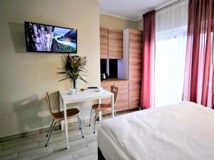 a bedroom with a table and chairs and a bed at VILLA PORTO in Krynica Morska