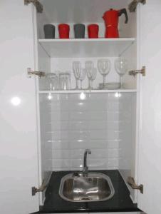 グラナダにあるAtico centroの- 棚にワイングラス付きのキッチンシンク