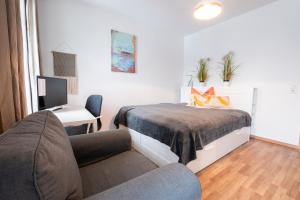 ein Schlafzimmer mit einem Bett, einem Schreibtisch und einem Sofa in der Unterkunft Lutherviertel-Apartment mit 2 SZ in Uni-Nähe in Chemnitz