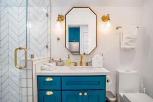 a bathroom with a blue cabinet and a mirror at Unique A-frame Tiny House in Houston Central in Houston +28 photos