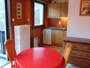 a kitchen with a red table with chairs and a sink at Studio Chamonix-Mont-Blanc, 1 pièce, 3 personnes - FR-1-517-27 in Chamonix