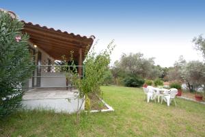 a house with a table and chairs in a yard at VOULA STUDIOS in Skiathos