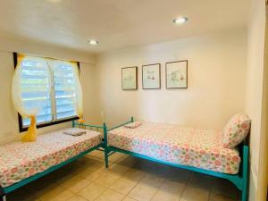 een kamer met 2 bedden en een raam bij Free WIFI 1st Floor Apartment in Punta Santiago