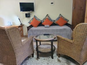 a room with a bed with a table and two chairs at Selati 103 Guest Cottages in Malelane