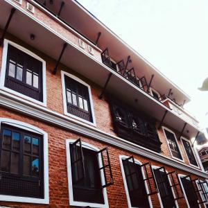 budynek z czerwonej cegły z czarnymi oknami w obiekcie Hotel Little Buddha Inn w Katmandu
