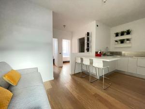 eine Küche und ein Wohnzimmer mit einem Sofa und einem Tisch in der Unterkunft Appartamento Gasparo da Salò in Salò