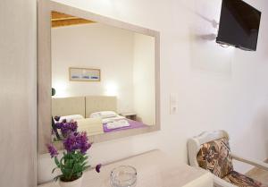 a mirror in a room with a bed and a couch at VOULA STUDIOS in Skiathos