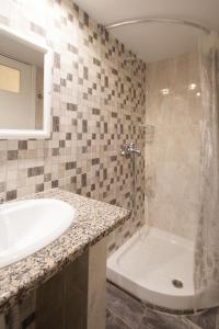 a bathroom with a sink and a shower and a tub at VOULA STUDIOS in Skiathos +7 photos
