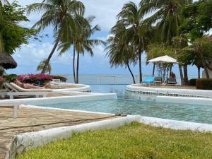 a swimming pool with a view of the ocean at White Lion in Malindi