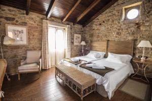um quarto com uma cama grande numa parede de pedra em Hotel Rustico Lugar Do Cotariño em Camariñas