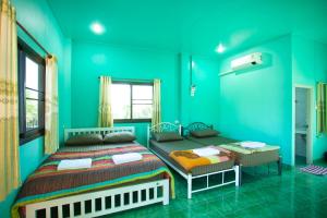 a blue bedroom with two beds and a window at บ้านเขาค้อริมธาร in Ban Non Na Yao