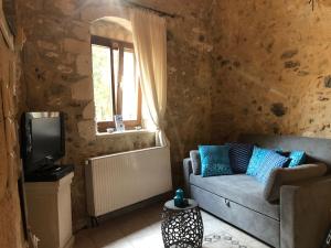 a living room with a couch and a tv at Guesthouse Arkadi Spa in Atsipopoulo