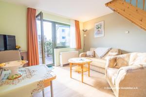 een woonkamer met een bank en een tafel bij Ferienwohnung Seestraße 67 in Zingst