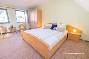 een slaapkamer met een groot bed en een tafel en stoelen bij Ferienwohnung Seestraße 67 in Zingst