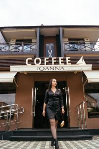 アドレルにあるIoanna Boutique Hotelの建物前に立つ女