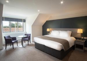 a hotel room with a bed and a table and chairs at Heacham Manor Hotel in Hunstanton
