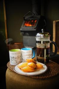 a table with a plate of fruit and a tea pot at The Bolt Hole in St Merryn