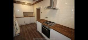 a kitchen with a stove and a counter top at Listed sword makers cottage in Shotley Bridge in Consett