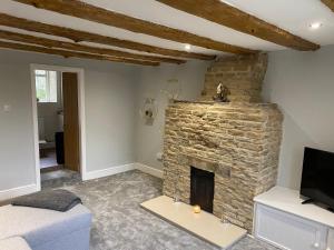 a living room with a stone fireplace and a couch at Listed sword makers cottage in Shotley Bridge in Consett