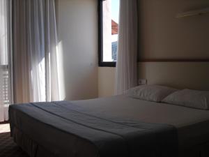 um quarto com uma cama grande e uma janela em Kerman Hotel em Cesme